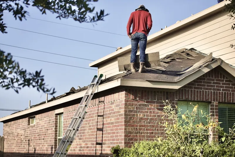 Professional roofer working on a residential roof in Heath